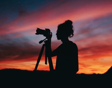 A zoomed in picture of a man holding a camera.